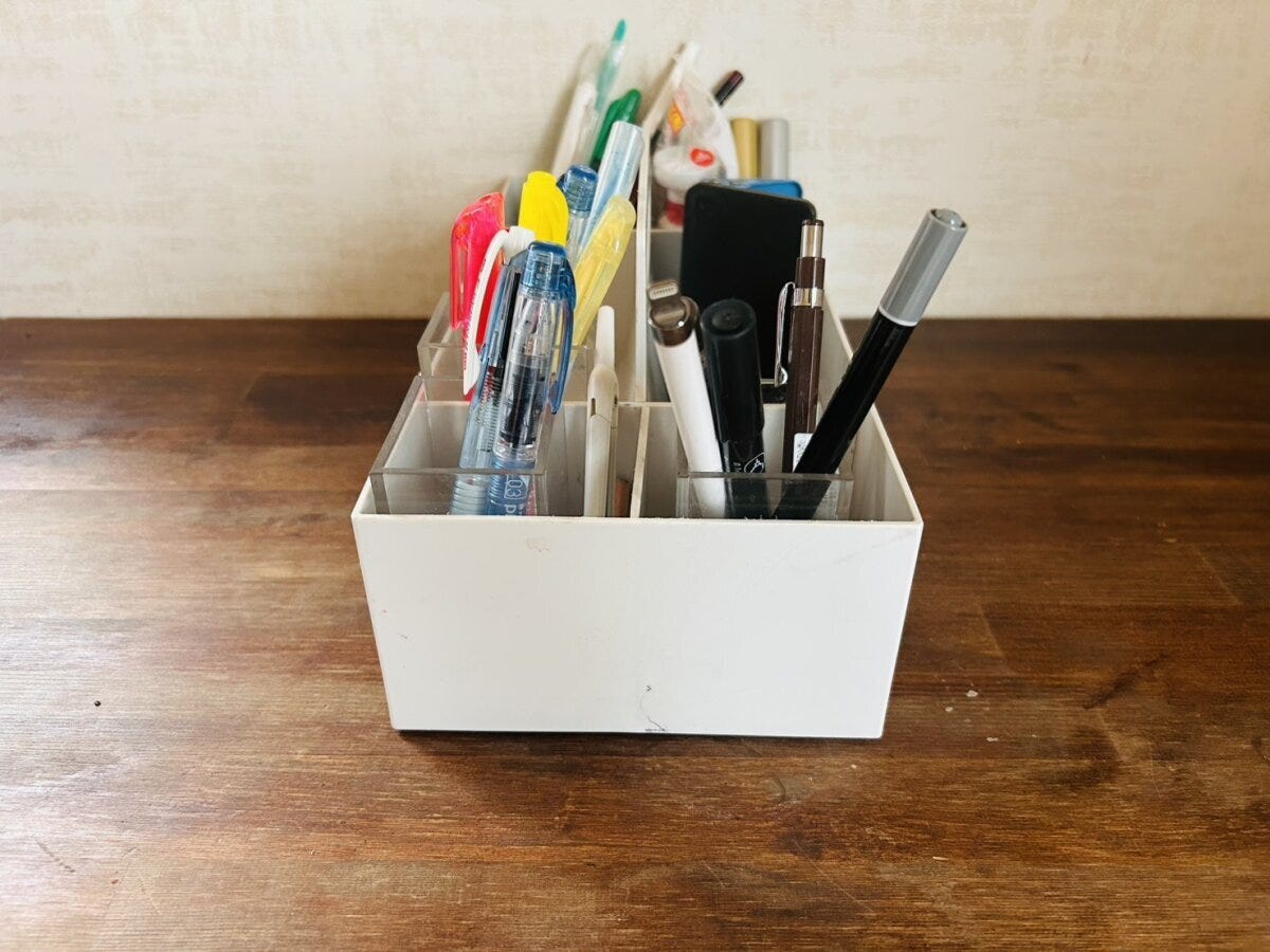 白いペン立てに文房具が種類ごとに整理されて収納されている 白いペン立てに文房具が種類ごとに整理されて収納されている