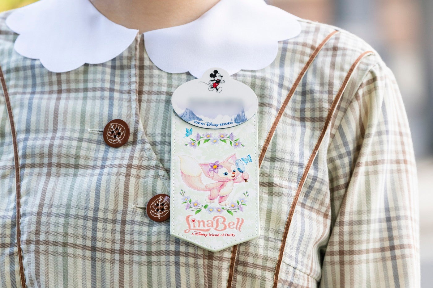 ネームタグアクセサリーを着用しているキャスト（C）Disney