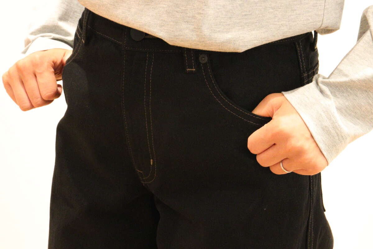 黒のジーンズのポケットに手を入れる女性の手元