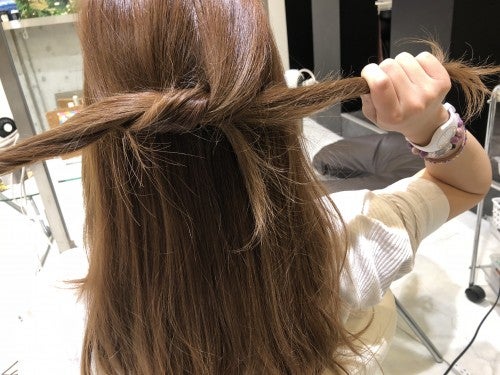 分けとったトップの髪をさらに2つに分けて髪同士をぎゅっと結びます。