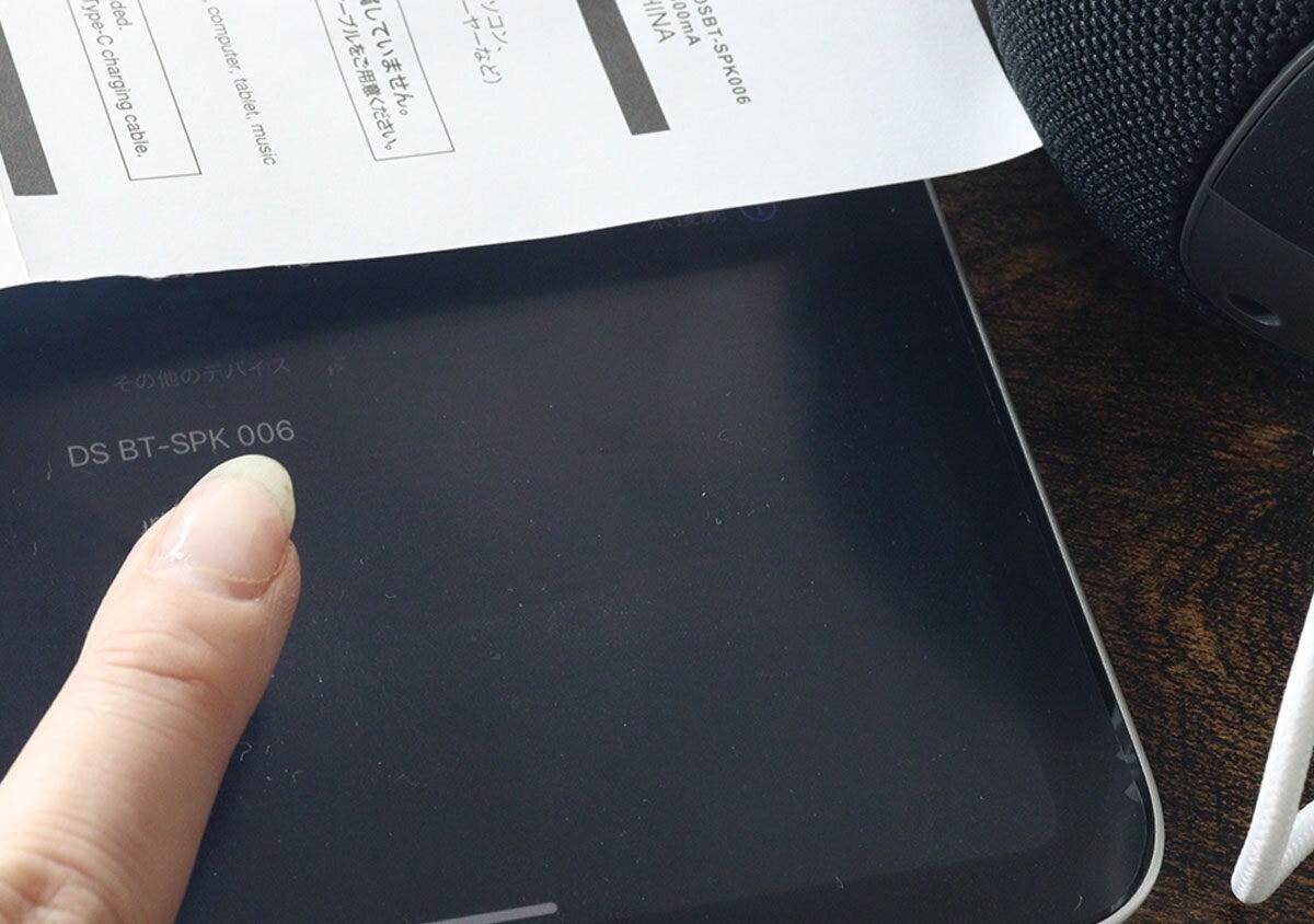 タブレット端末の画面に表示されたデバイス名を指でタップしているところ タブレット端末の画面に表示されたデバイス名を指でタップしているところ