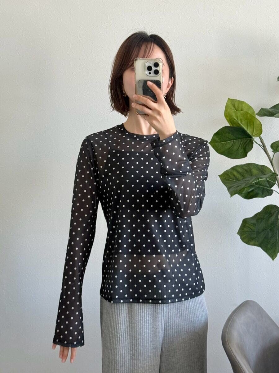 黒ドット柄シアーTを着てスマホで自撮りする女性 黒ドット柄シアーTを着てスマホで自撮りする女性