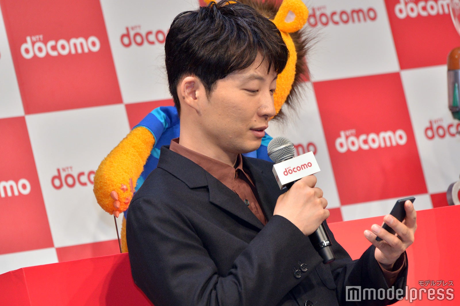 名刺サイズの「カードケータイ」をチェックする星野源（C）モデルプレス