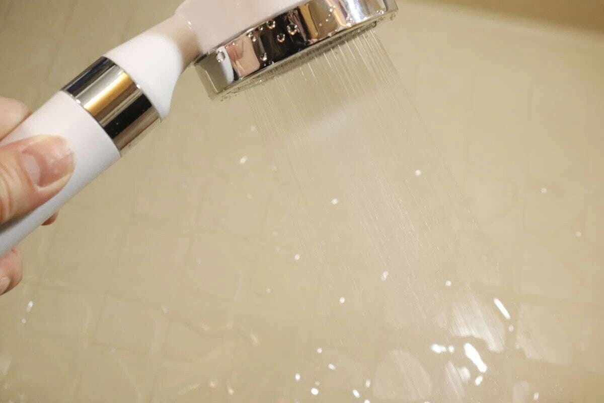手で持ったシャワーヘッドから細かな水が勢いよく出ている