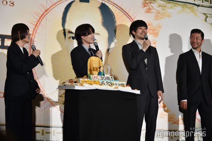 バースデーケーキを見たいが遠くのカメラだけを見るチャレンジをしているので見れない松山ケンイチとそれを見て笑っている杉咲花、神木隆之介、浅野忠信(C)モデルプレス