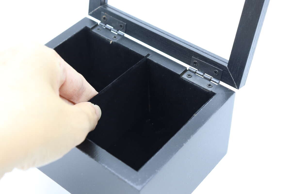 収納BOX内部の仕切り板を指で触っている様子