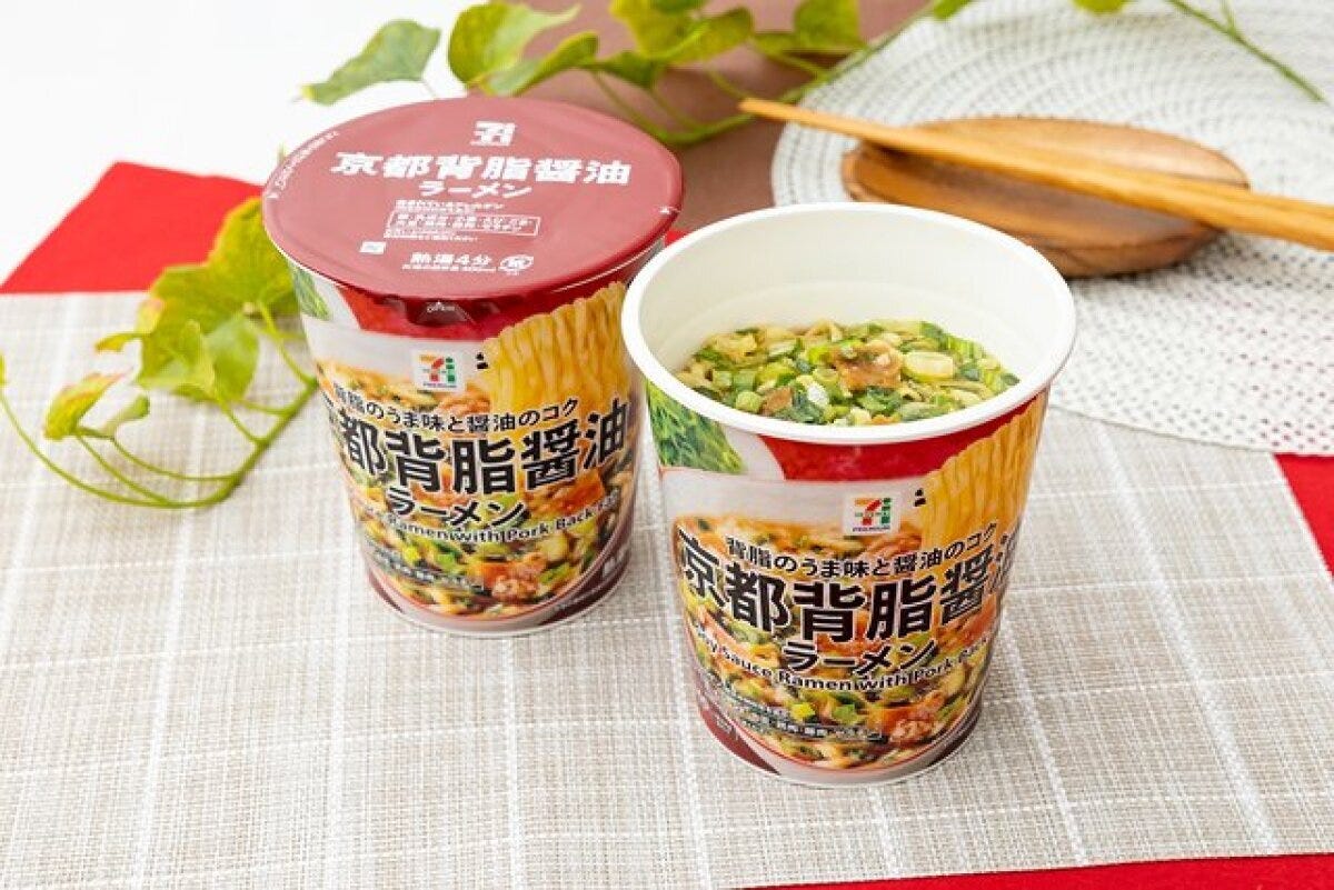 赤い蓋のカップ麺が2つ、一つは蓋が閉まり、もう一つはネギと具材が見える