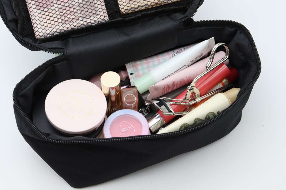 黒いメイクポーチのメイン収納にコスメがたっぷり入っている