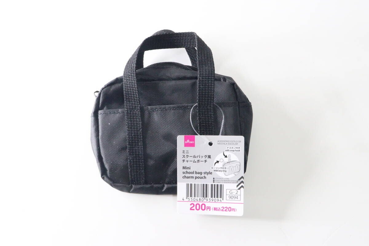 黒いミニスクールバッグ風チャームポーチが商品タグ付きで置かれている