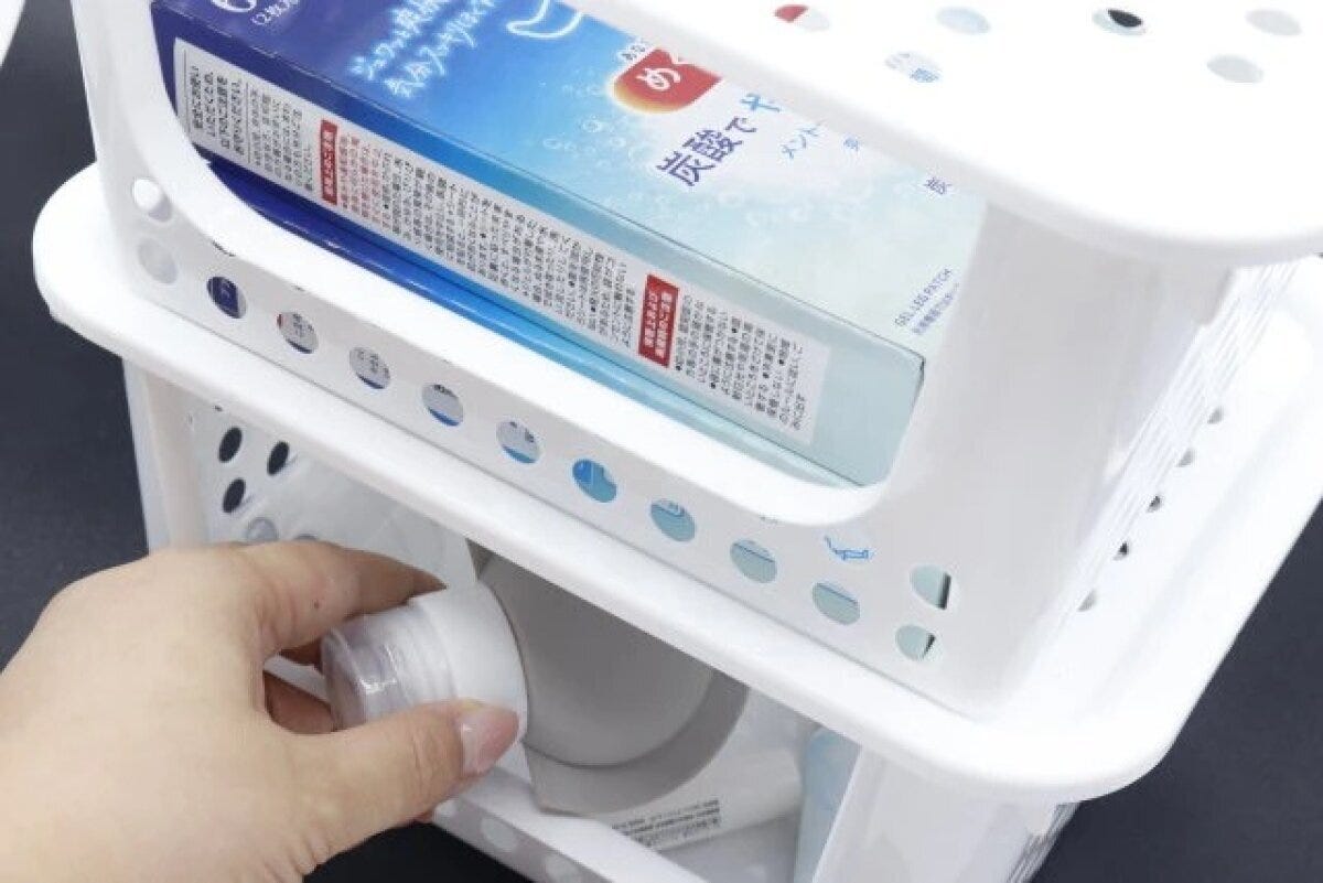 スタッキングされたべジストッカーの下段から化粧品を取り出す手元。