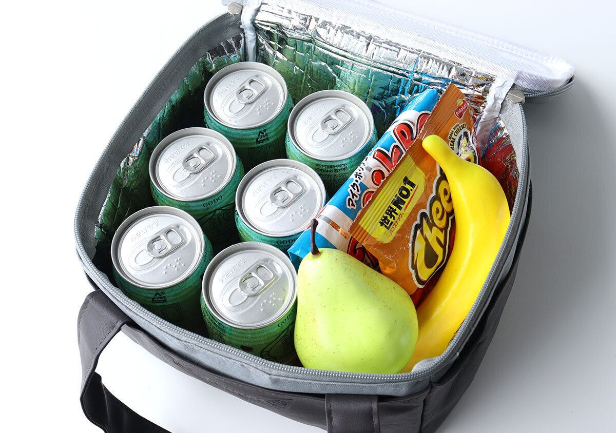 保冷バッグの中に缶飲料6本と果物、お菓子が入っている 保冷バッグの中に缶飲料6本と果物、お菓子が入っている