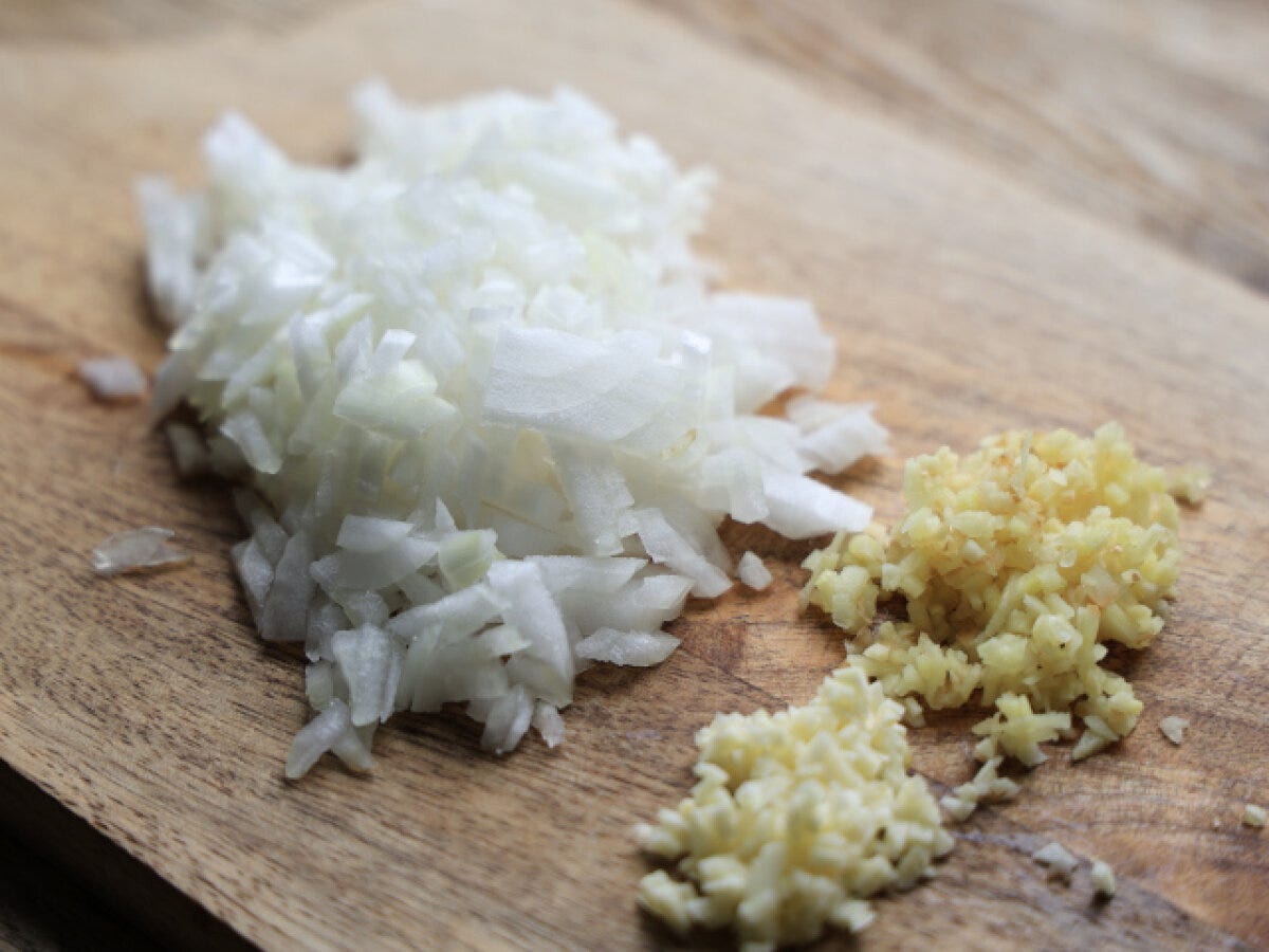 まな板に並んだみじん切りの玉ねぎ・にんにく・しょうが