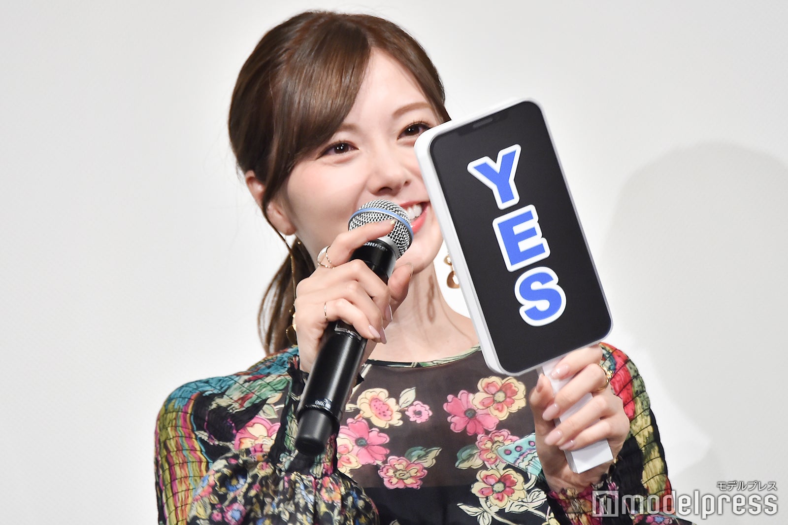 スマホ型の札をしげしげと眺める白石麻衣 （C）モデルプレス