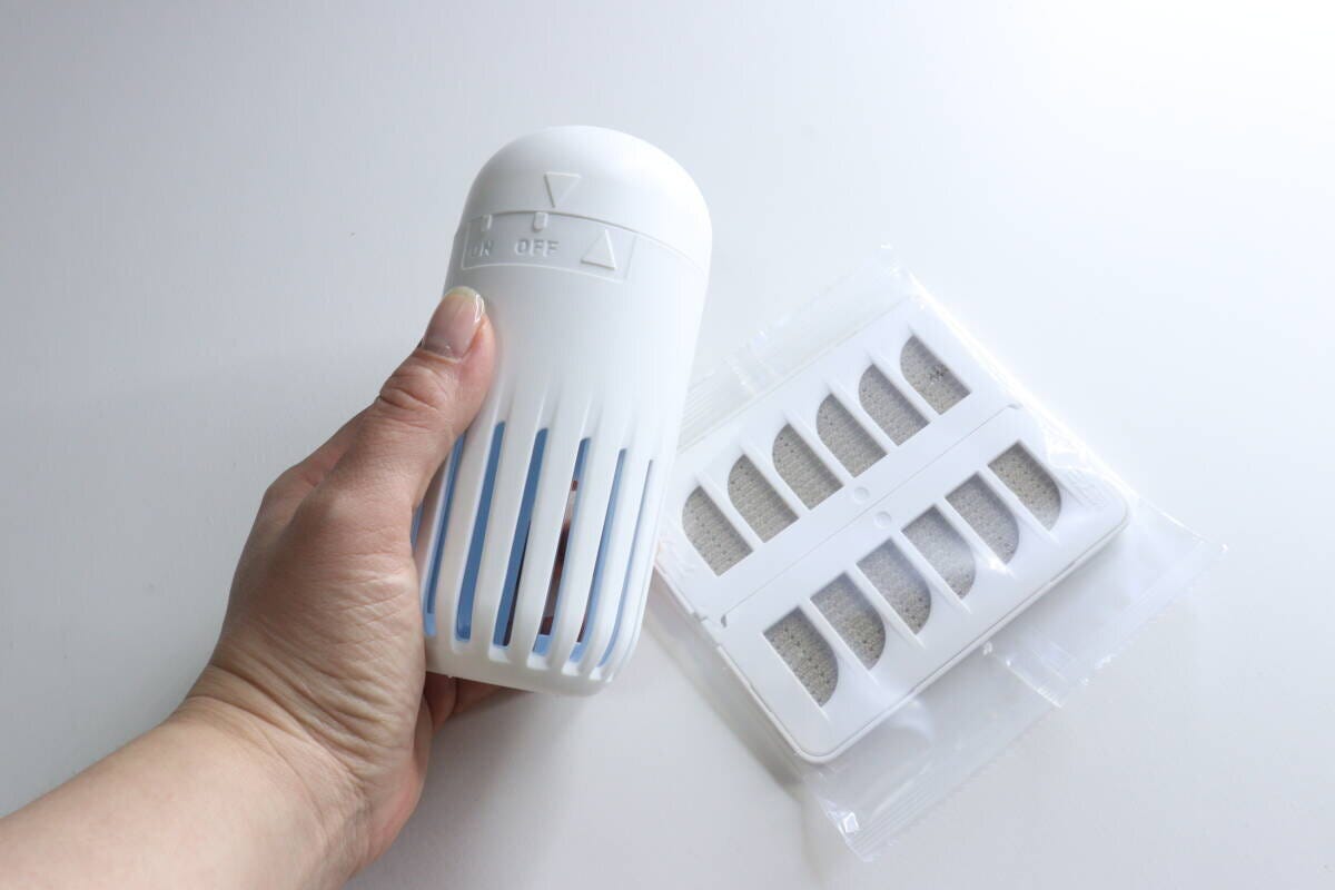 容器と袋に入った薬剤カートリッジを持つ女性の手