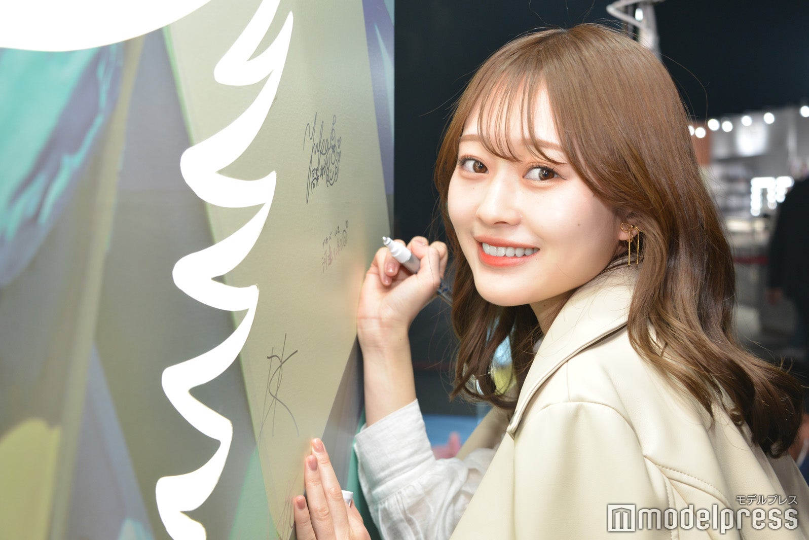 「ANGEL CHAMPAGNE」パネルにサインを書く河邊仁紀（C）モデルプレス