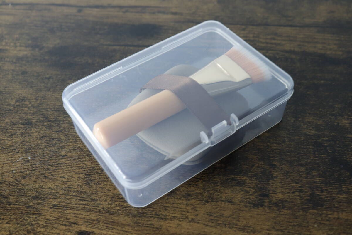 透明なプラスチックケースに収納されたメイクパフとメイクブラシ 透明なプラスチックケースに収納されたメイクパフとメイクブラシ