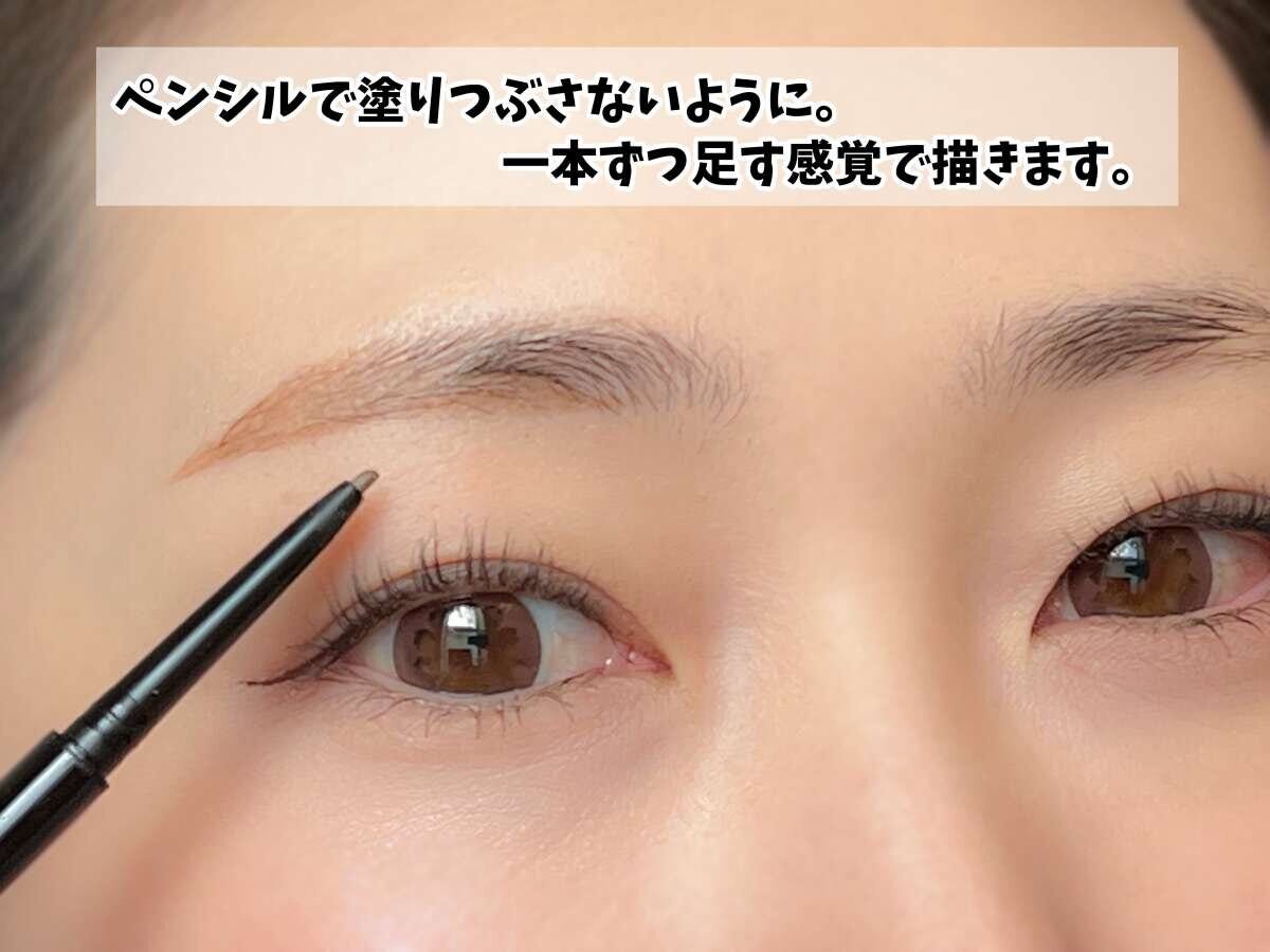 女性がアイブロウペンシルで眉中央の毛を一本ずつ描き足す様子 女性がアイブロウペンシルで眉中央の毛を一本ずつ描き足す様子