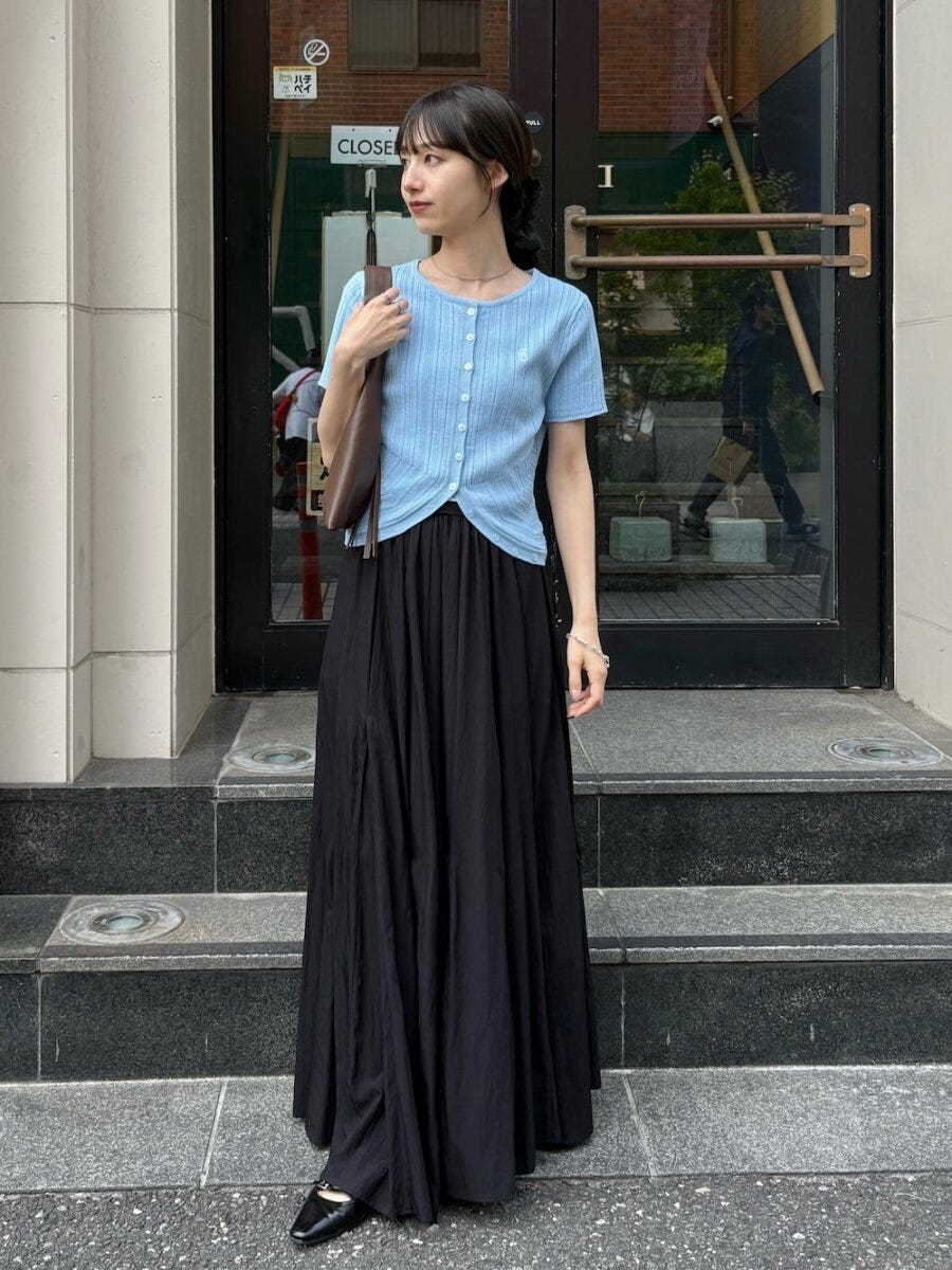 アイスブルーのカーデと黒ロングスカートの女性 アイスブルーのカーデと黒ロングスカートの女性