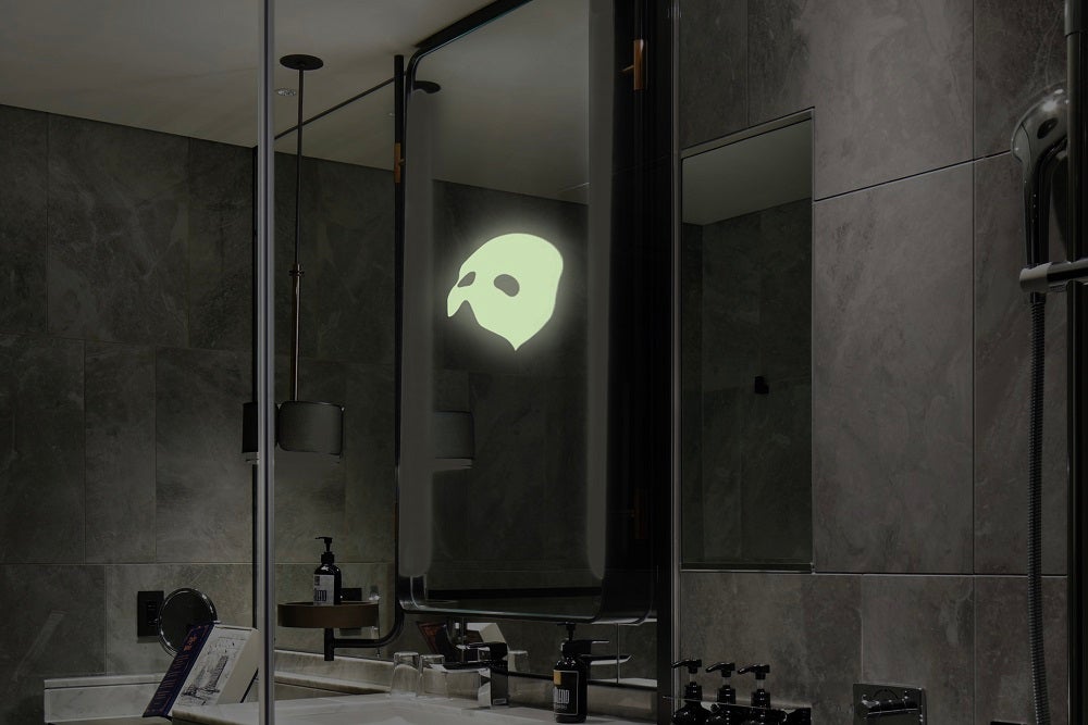 暗闇の中鏡に浮かび上がる怪人の仮面／画像提供：JR東日本ホテルズ