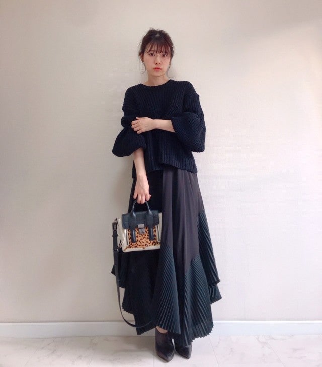 黒のボリュームスリーブニットにロングスカートを合わせ、レオパード柄ハンドバッグと黒のブーティをコーディネート