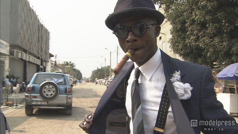 未舗装の道を闊歩するサプール（C）NHK