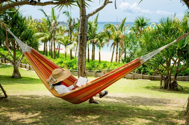 波音を聞きながらビーチサイドのハンモックで読書／画像提供：カヌチャベイリゾート