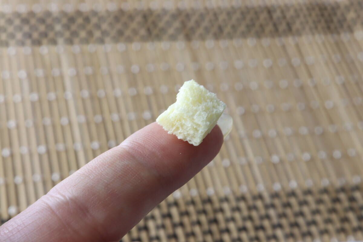 人差し指の先に、四角いクルトンが1粒乗っている 人差し指の先に、四角いクルトンが1粒乗っている