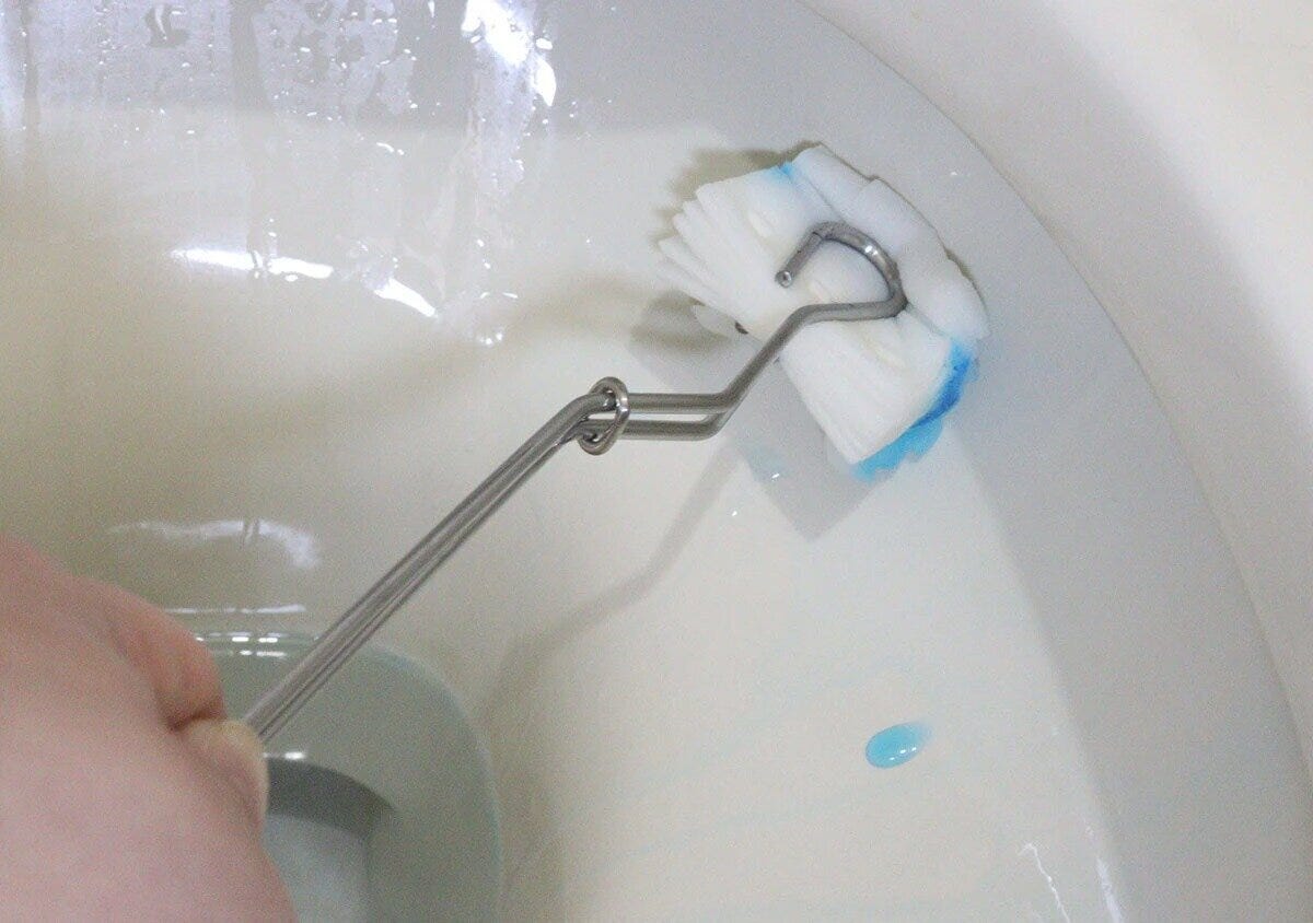 手がステンレス製トイレブラシで便器内をゴシゴシ掃除している 手がステンレス製トイレブラシで便器内をゴシゴシ掃除している