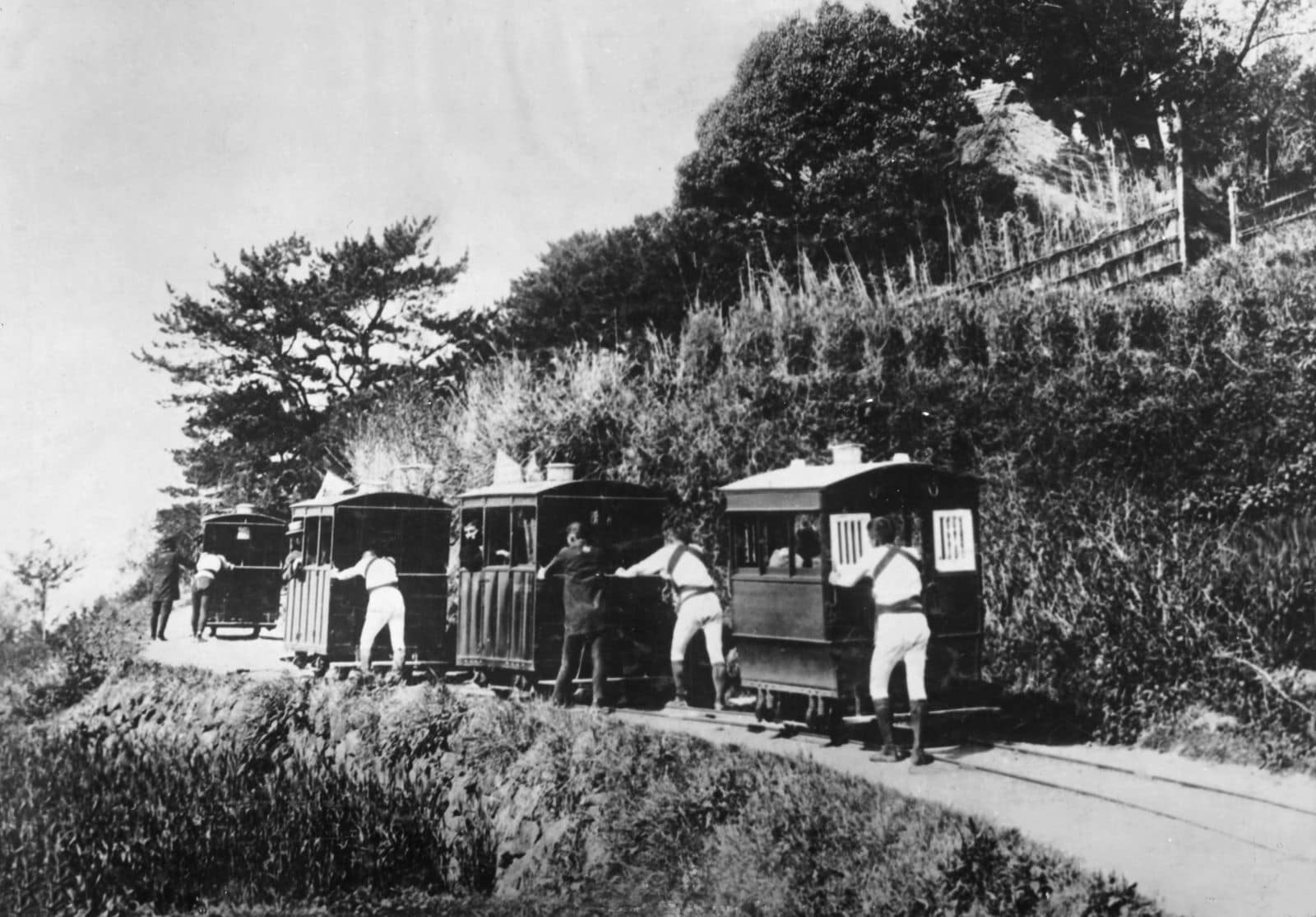 車夫に押され連なって進む豆相人車鉄道の車両（提供：今井写真館）