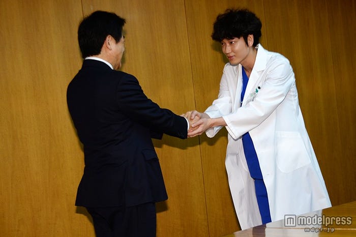 塩崎恭久大臣(左)と握手を交わす綾野剛(右)