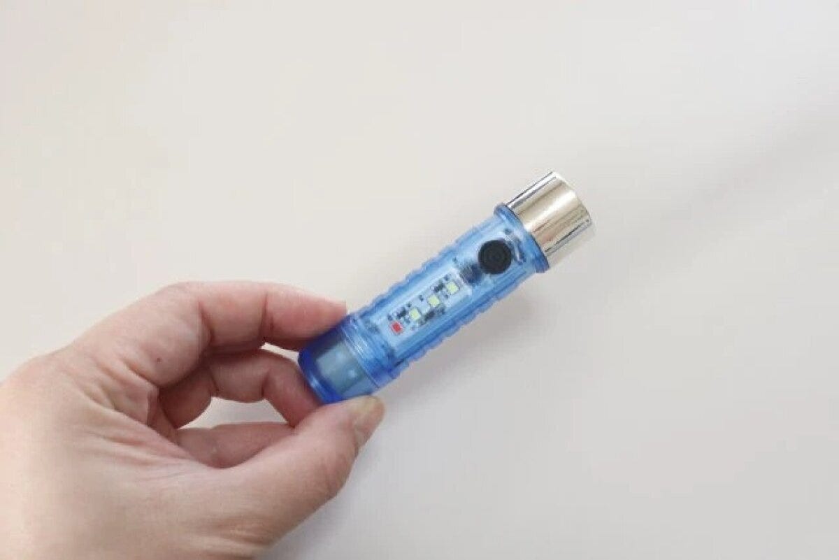 手に持った青いスケルトンデザインの充電式LEDライト