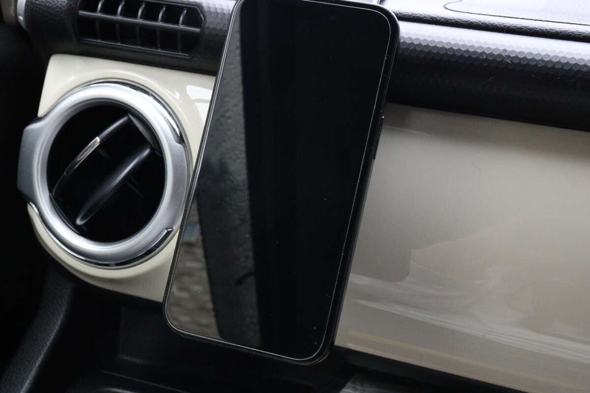 車のダッシュボードに設置された車載ホルダーにスマートフォンが固定されている 車のダッシュボードに設置された車載ホルダーにスマートフォンが固定されている