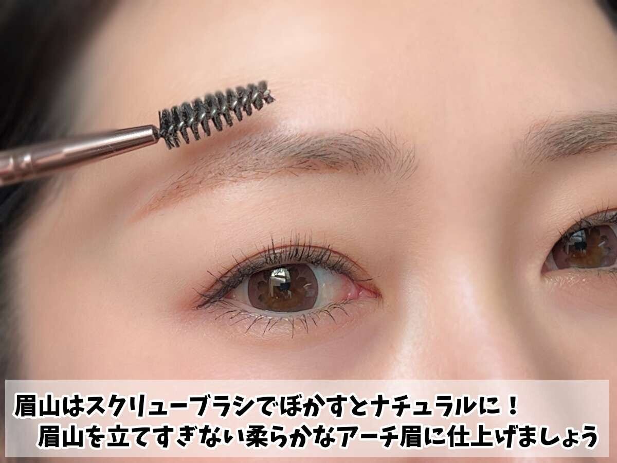 スクリューブラシで眉山をぼかし、眉を整えている女性の顔のアップ