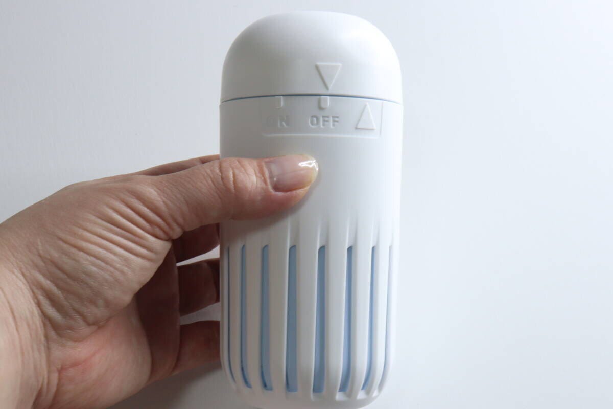 容器のフタをONの位置に動かす女性の手