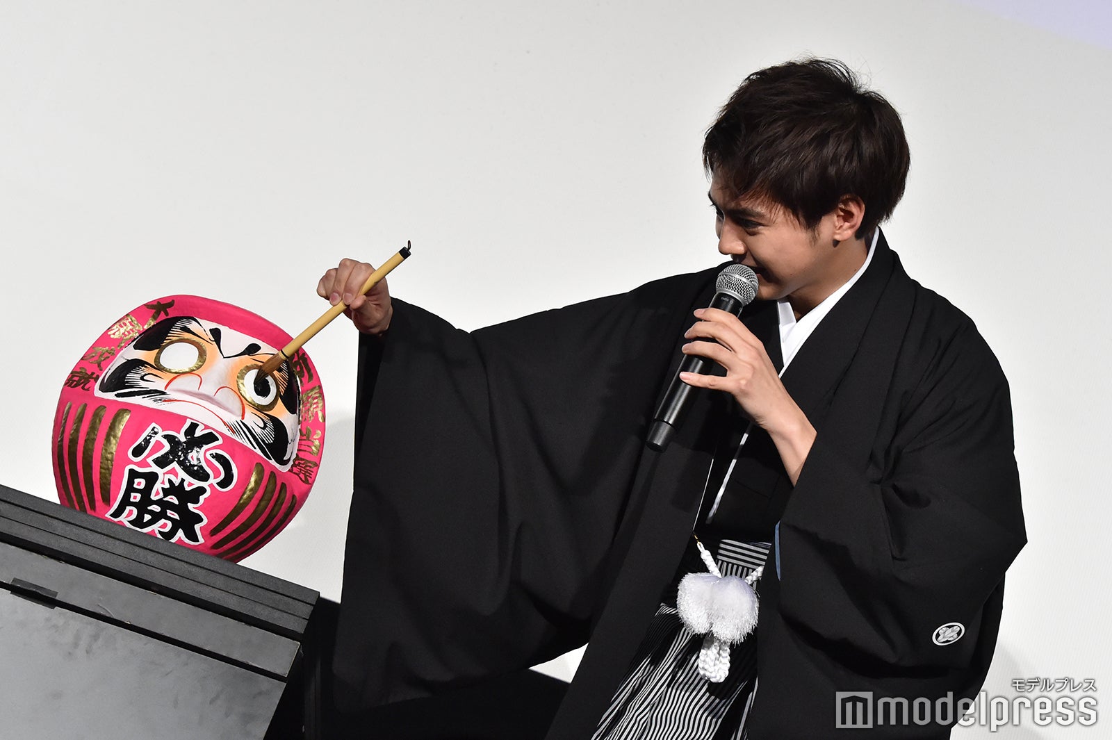 慎重にだるまの目入れをする片寄涼太 （C）モデルプレス