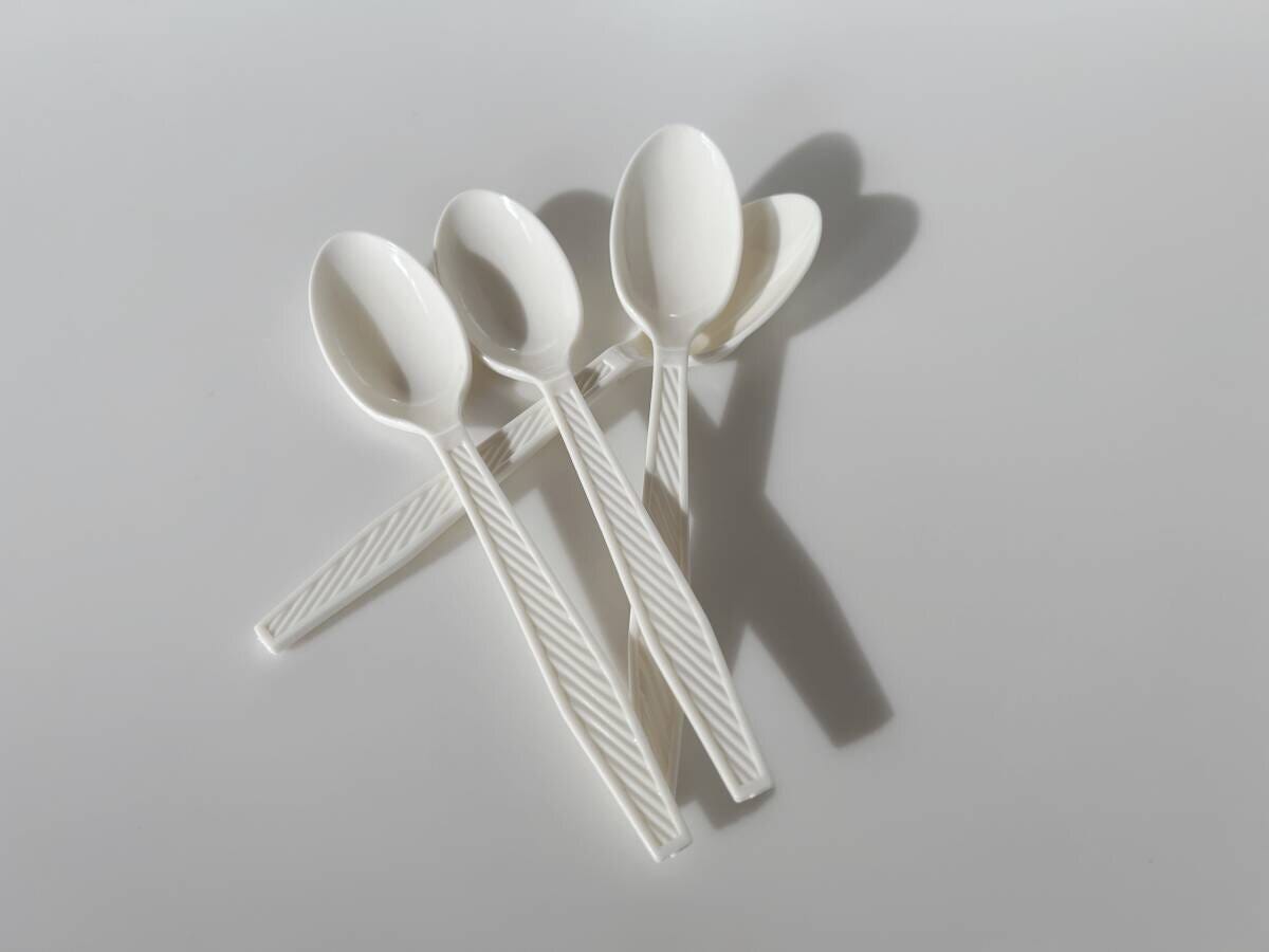 白い使い捨てプラスチックスプーン3本が重なって置かれた俯瞰写真