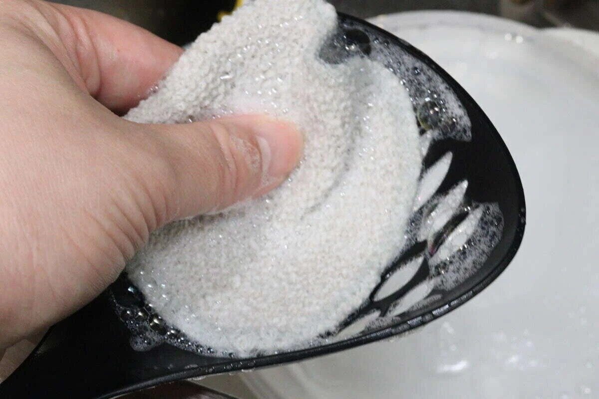 ベージュのかたやわクロスで泡立てながら調理器具を洗う手元