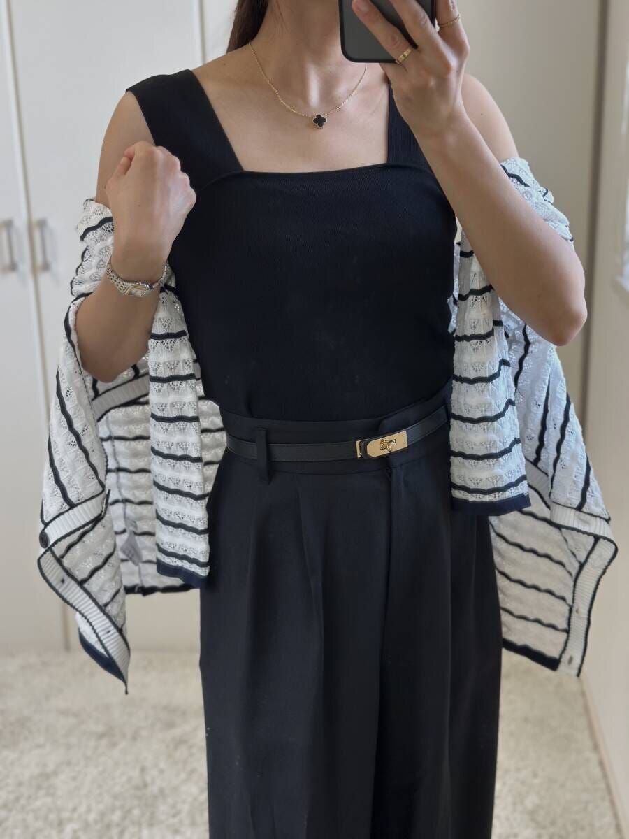 黒いニットインナーとワイドパンツにボーダーカーディガンを肩掛けした女性 黒いニットインナーとワイドパンツにボーダーカーディガンを肩掛けした女性