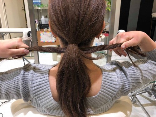 くくった髪の外側にある毛束をとり、ギューっと締める