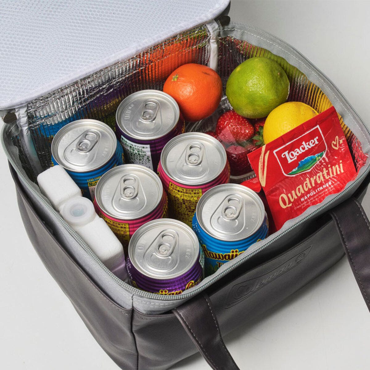 Coleman保冷バッグの中に缶飲料6本、果物、お菓子、保冷剤が入っている様子 Coleman保冷バッグの中に缶飲料6本、果物、お菓子、保冷剤が入っている様子