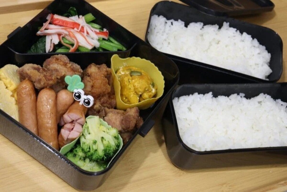 ご飯とおかずが彩りよく詰められた三分割弁当箱