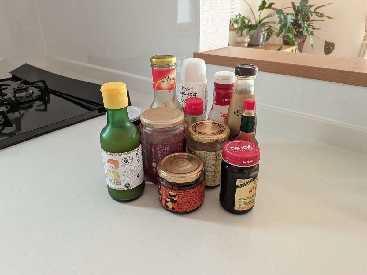 キッチンカウンターに並べられた期限をチェックする瓶詰めや調味料の写真