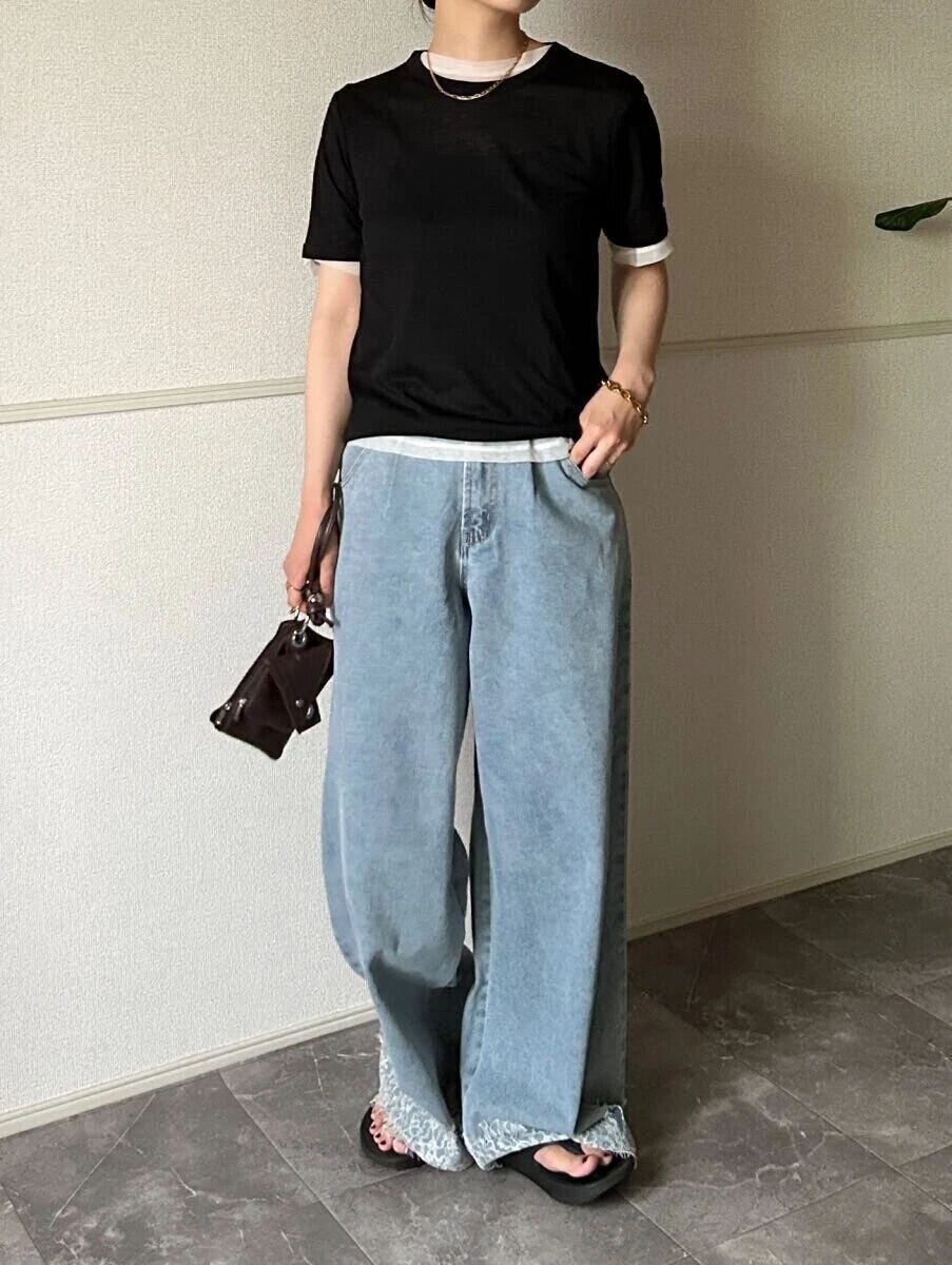 黒シアーTと白インナー、ワイドデニムの女性