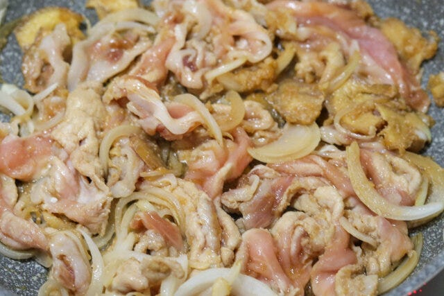 たまねぎに焼き色がついたら、調味料をもみ込んでおいた豚肩ロース肉を加えて炒める。